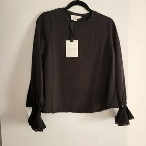 Pomander Place black top with detail around cuffs and bottom of top. Never worn.